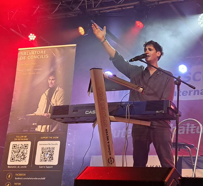 Salvatore De Concilis performing at the piano under red and purple stage lights